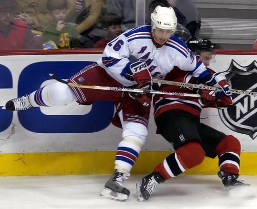 Martin Ručinský z NY Rangers (v bílém) atakuje hráče New Jersey Briana Rafalskiho. | Foto: ČTK/AP