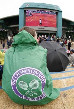 Fanoušci, kteří se nedostali na kurty, sledují Wimbledon na obří obrazovce. | Foto: Reuters