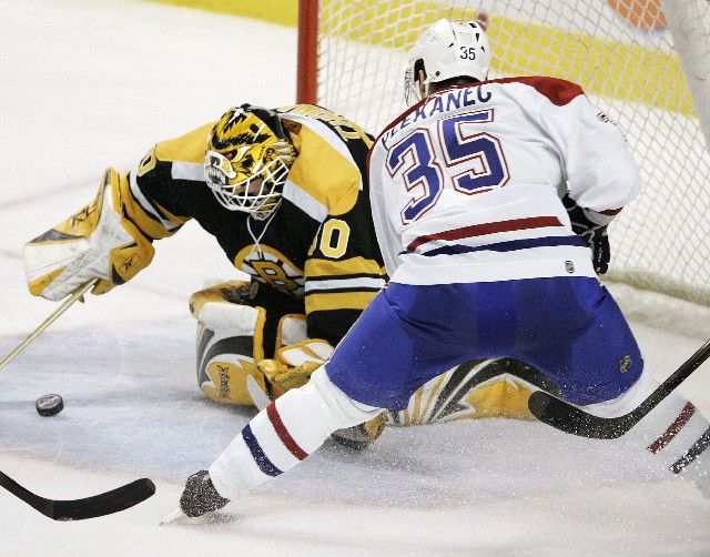 Gólman Bostonu Bruins Tin Thomas (vlevo) skrývá puk před Tomášem Plekancem z Montrealu. | Foto: Reuters