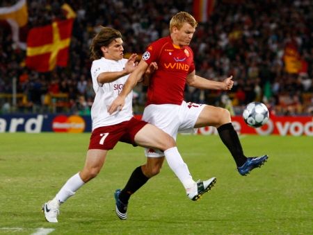 John Arne Riise (vpravo) z AS Řím se předhání Juanem Culiem z Kluže v úvodním utkání Ligy mistrů v Římě. | Foto: Reuters