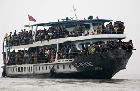 Severokorejci na vyhlídkové lodi se plaví po řece Ja-lu, která odděluje Severní Koreu od Číny | Foto: REUTERS / Reinhard Krause