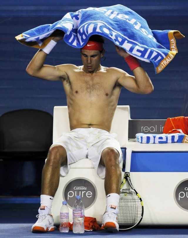 Rafael Nadal se před deštěm chránil po svém. | Foto: Reuters