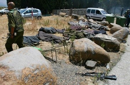 Izraelský voják prochází kolem zakrytých těl svých kolegů, kteří zahynuli, když raketa Hizballáhu zasáhla vesnici Kfar Giladi. | Foto: Reuters