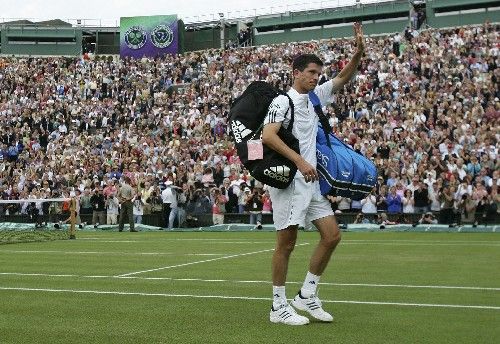 Domácí tenista Tim Henman se loučí s diváky ve Wimbledonu poté, co ve druhém kole vypadl se Španělem Felicianem Lopezem. | Foto: Reuters