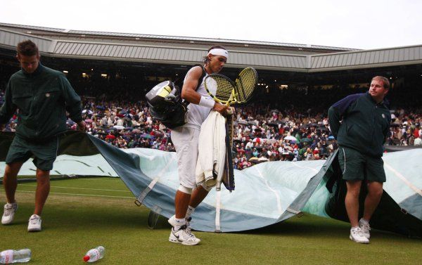 Na triumf si musel počkat. Rafael Nadal opouští kurt poté, co bylo wimbledonské finále přerušeno kvůli dešti. | Foto: Reuters