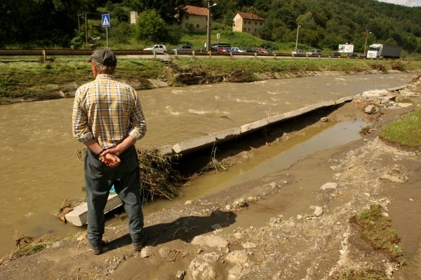 Tam vzadu, co jsou ty schůdky, tam není železná lávka, co tu ještě v neděli ráno byla. Na otázku kde je, pokrčí tento muž rameny. V korytě říčky Handlovky po ní  není ani památky. Silnice na Prievidzu byla po povodni neprůjezdná. Od světa byla na čas odříznuta také čtvrť Handlové Nová Lehota. | Foto: Karel Toman