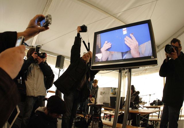 Novináři fotografují z obrazovky příchod Fritzla do soudní síně. | Foto: Reuters