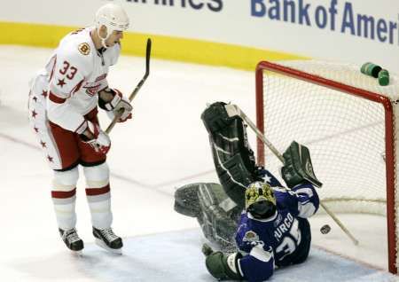 Zdeno Chára v dresu Východní konference překonává v zápase hvězd NHL gólmana Marty Turca. | Foto: Reuters