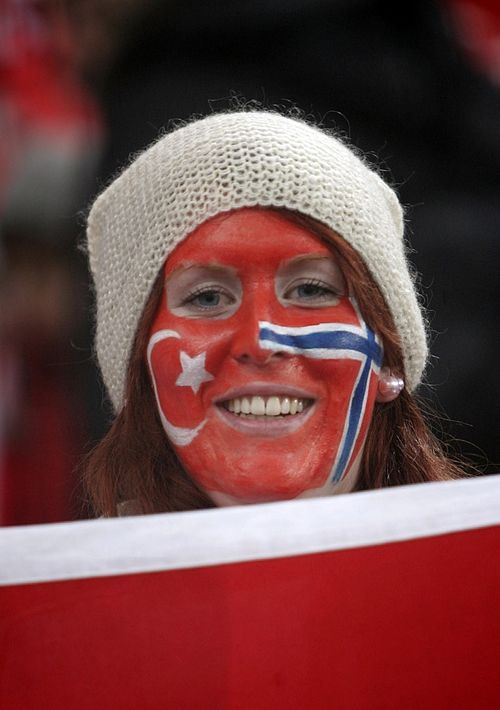 Jedna z divaček dorazila na zápas Norska s Tureckem s tváří v barvách obou soupeřů. | Foto: Reuters