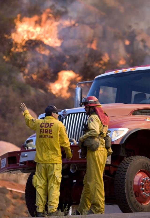 Požárníci východně od San Diega rozebírají strategii, jak zastavit plameny. To se nedaří, oheň stále rozdmýchává silný vítr. | Foto: Reuters