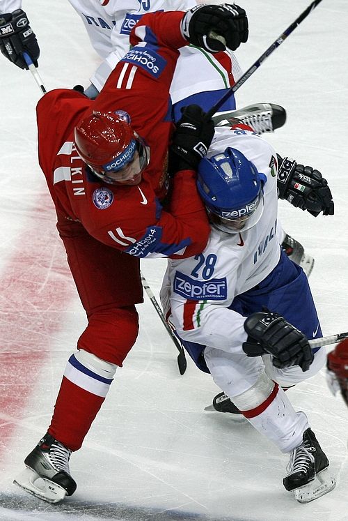 Rus Jevgenij Malkin (v červeném) atakuje Manuela de Toniho z Itálie. | Foto: Reuters