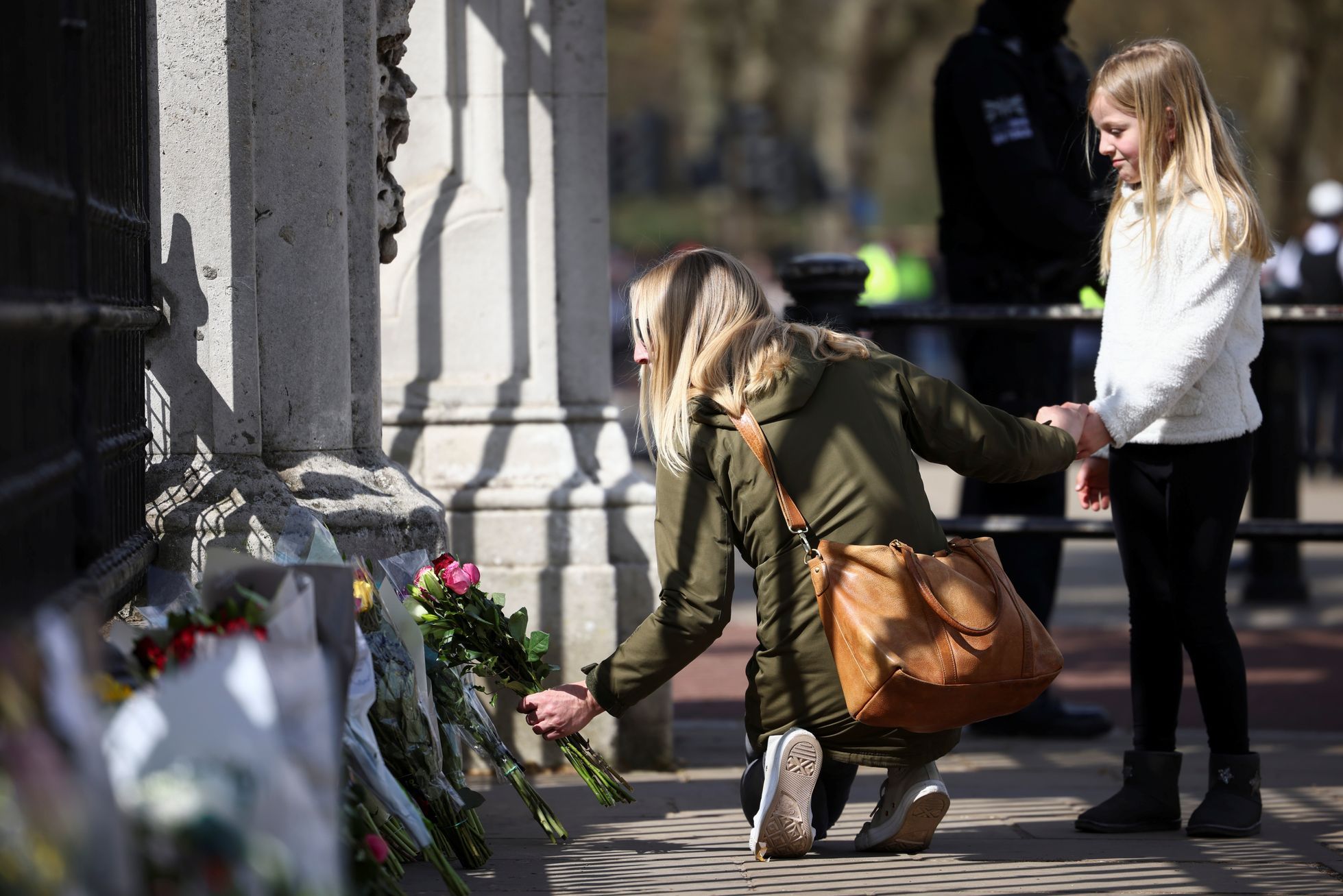 People wear flowers in front of Buckingham Palace and quietly worship the memory of Prince Philip