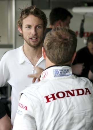 Pilot Hondy Jenson Button (vlevo) hovoří s týmovým kolegou Rubensem Barrichellem na okruhu v Bahrainu. | Foto: Reuters