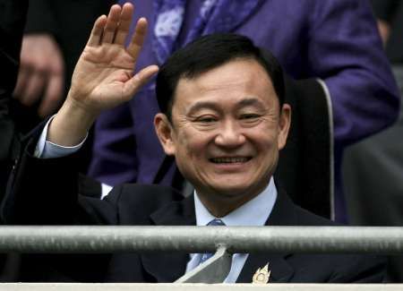 Thaksin zdraví své příznivce v hledišti fotbalového stadiónu klubu Manchester City, který mu patří | Foto: Reuters