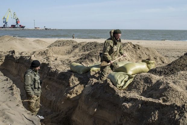 Ukrajinští vojáci v zákopech na pláži u mariupolského přístavu. | Foto: Reuters