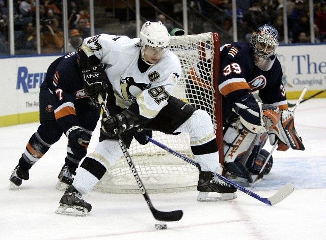 Hokejista Pittsburgu Penguins Sidney Crosby (uprostřed) objíždí branku Ricka DiPietra z New York Islanders. | Foto: Reuters