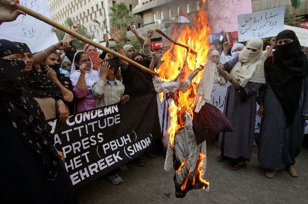 Protestující pálí figurínu dánského ministerského předsedy Anderse Fogha Rasmussena během protestů proti karikaturám v pákistánském Karáčí. | Foto: Aktuálně.cz