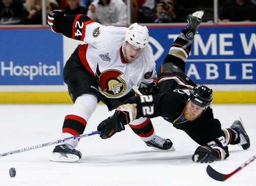 Todd Marchant z Anaheimu (vpravo) se ocitl na zemi po zákroku ottawského Antona Volčenkova. | Foto: Reuters