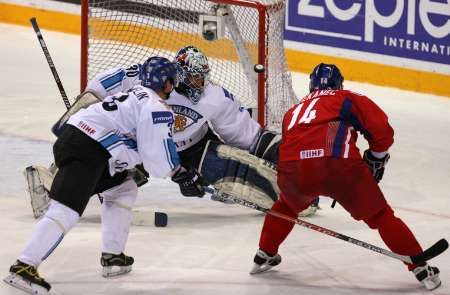 Tomáš Plekanec (v červeném) v oslabení překonává finského brankáře Fredrika Norrenu. Vlevo Petteri Nummelin. | Foto: Reuters