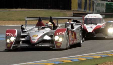 Lucas Luhr s Audi R10 vede závod 24 godin v Le Mans před Sébastienem Bourdaisem s Peugeotem 908. | Foto: Reuters