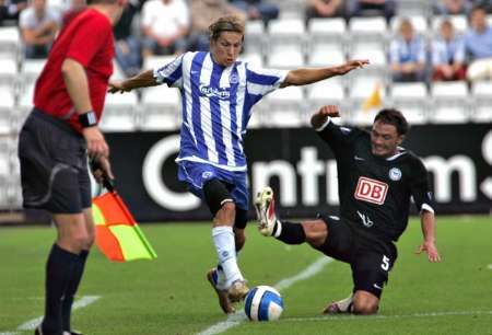 Tobias Grahn z Odense (uprostřed) atakovaný Sofianem Chahedem z berlínské Herthy. | Foto: Reuters