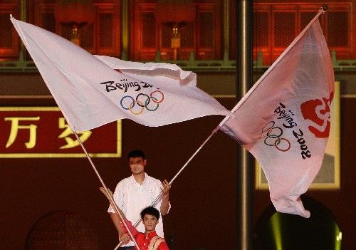 Čínský basketbalista Jao Ming nese s vlajkou OH v Pekingu na slavnostním ceremoniálu, při kterém Číňané slavili rok do olympiády. | Foto: Reuters