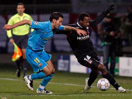 Fotbalista Lyonu Govou (vpravo) v souboji s barcelonským Zambrottou | Foto: Reuters