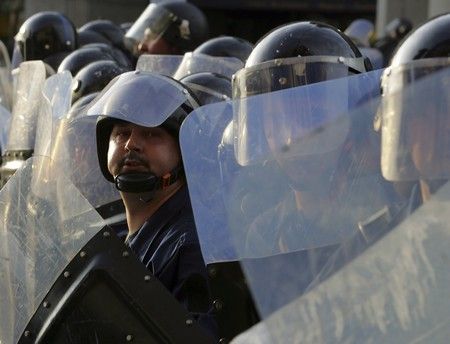 Maďarský policista pozoruje demonstranty | Foto: Reuters