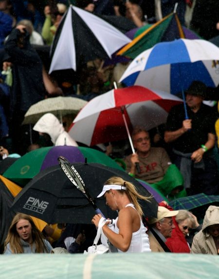 A rychle pryč, zase nám ve Wimbledonu prší. | Foto: Reuters