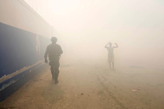 Kouř z páleného dřeva na ulicích Cité Soleil. | Foto: Reuters