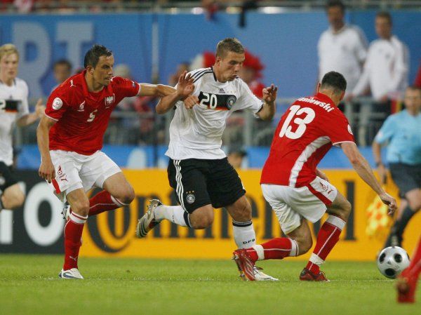 Německý útočník Lukas Podolski se probíjí polskou obranou( (vlevo Dariusz Dudka, vpravo Marcin Wasilewski). | Foto: Reuters