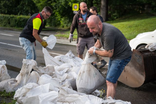 Pracovníci odklízejí pytle s pískem, které zabraňovaly větším škodám při bleskové povodni v Českém Krumlově. | Foto: ČTK