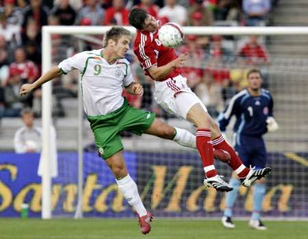 Daniel Agger z Dánska v souboji s irským útočníkem Kevinem Doylem | Foto: Reuters