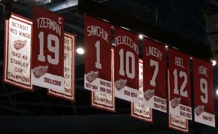 Dres bývalého kapitána Steva Yzermana (vlevo) se ocitl pod střechou Joe Louis Areny vedle dalších legend Detroitu Red Wings. | Foto: Reuters