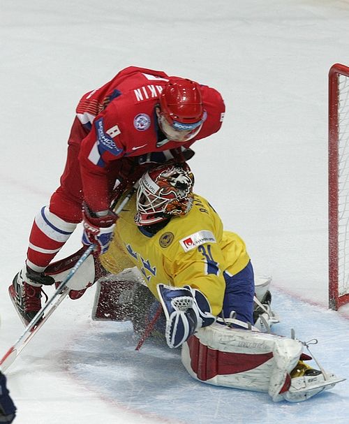 Ruský útočník Alexander Ovečkin (v červeném) atakuje gólmana Švédska Johana Backlunda. | Foto: Reuters