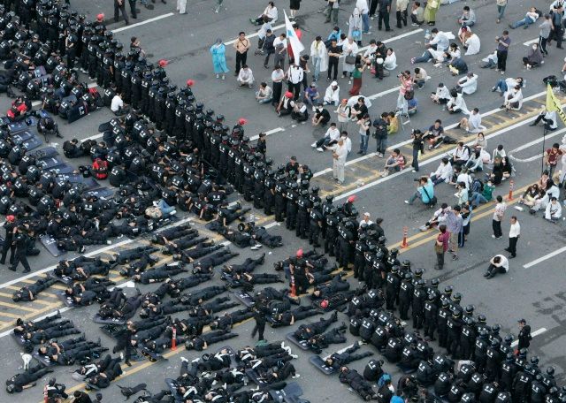 Policisté jsou neustálými demonstracemi už vyčerpáni. Spí přímo na ulicích | Foto: Reuters