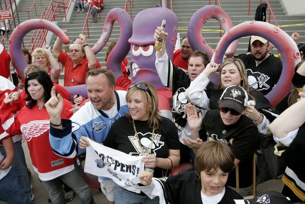 Fanoušci Detroitu i Pittsburghu společně pózují mezi chapadly chobotnice, odvěkého symbolu detroitské účasti ve finále Stanleyova poháru. | Foto: Reuters