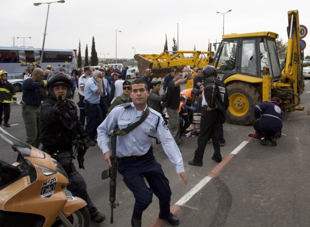 Policisté na místě útoku, v pozadí buldozer. | Foto: Reuters