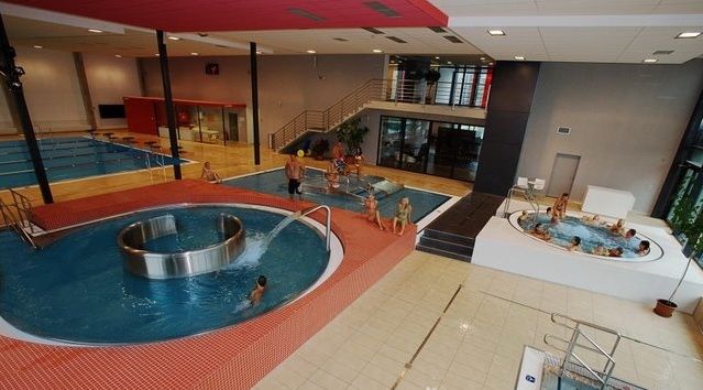 Aquapark v Rychnově nad Kněžnou je vybaven plaveckým bazénem, divokou řekou, tobogány i vířivkami. Pro pohodlí návštěvníků jsou k dispozici dva bary, suchý a mokrý. V obou se dá platit bezhotovostně pomocí čipové karty, na kterou si návštěvník může uložit peníze. | Foto: Plavecký bazén Rychnov nad Kněžnou