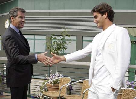 Do Wimbledonu dorazila na poslední dny řada celebrit, na snímku se Federer zdraví s hercem Piercem Brosnanem | Foto: Reuters