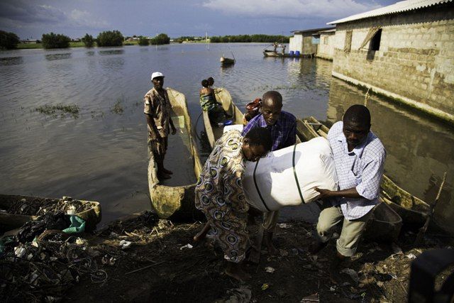 Dobrovolníci rozvážejí bezplatné moskytiéry do odlehlé vesnice přístupné pouze po vodě. Bohiconský region, Benin. | Foto: WHO/Benoist Carpentier