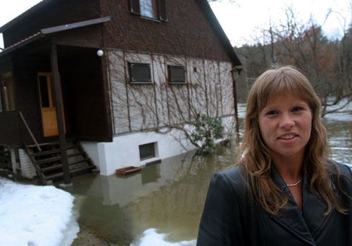 Paní Markéta Tomšů se tento týden jezdí na svou chalupu dívat každý den z Prahy. "Podle toho okénka u sklepa vždy pozoruji, o kolik se voda zvedla," říká. Na povodně je zvyklá, její rodina tu má chatu již několik desítek let. | Foto: Aktuálně.cz, Ondřej Besperát