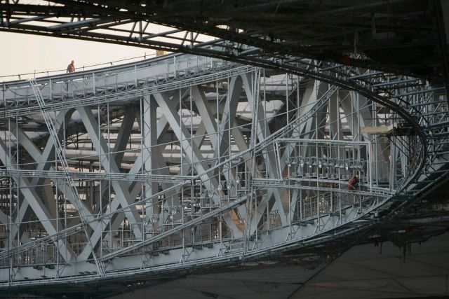 Jeden z dělníků pracujících na stavbě pekingského olympijského stadionu se prochází po jeho střeše. | Foto: Reuters