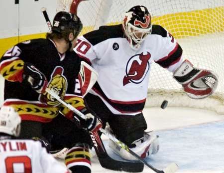 Brankář New Jersey Devils Martin Brodeur sleduje puk z hole útočníka Ottawy Senators Václava Varadi. | Foto: Reuters