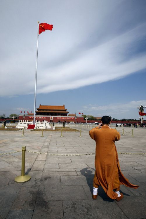 Budhistický mnich si fotí pekingské náměstí Tiananmen. | Foto: Reuters