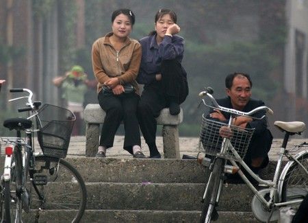 Ženy ve městě Sinujiu na severokorejské straně řeky Ja-lu, která odděluje Severní Koreu od Číny | Foto: REUTERS / Reinhard Krause