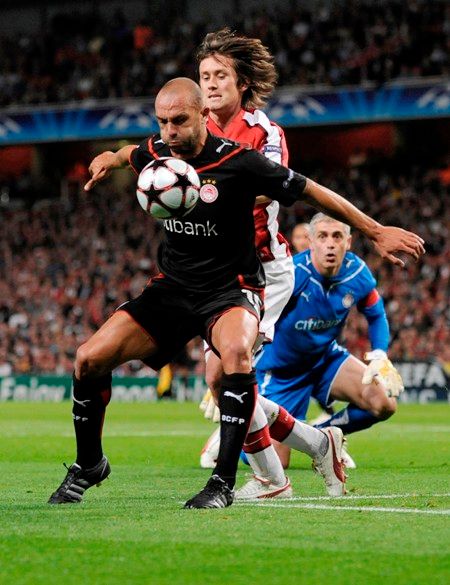 Tomáš Rosický z Arsenalu bojuje o míč s Raulem Bravem z Olympiakosu. | Foto: Reuters