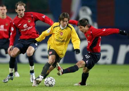 Tomáš Rosický z Arsenalu (ve žlutém) proniká mezi hráči CSKA Moskva Elvirem Rahimicem (vlevo) a Jevgenijem Aldoninem. | Foto: Reuters