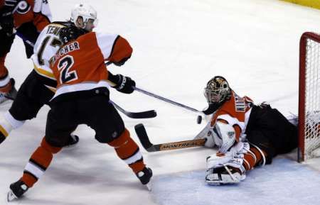 Petr Tenkrát z Bostonu (v bílém) skóruje do branky philadelphského gólmana Antero Niittymäkiho, byť byl tísněný obráncem Drianem Hatcherem. | Foto: Reuters