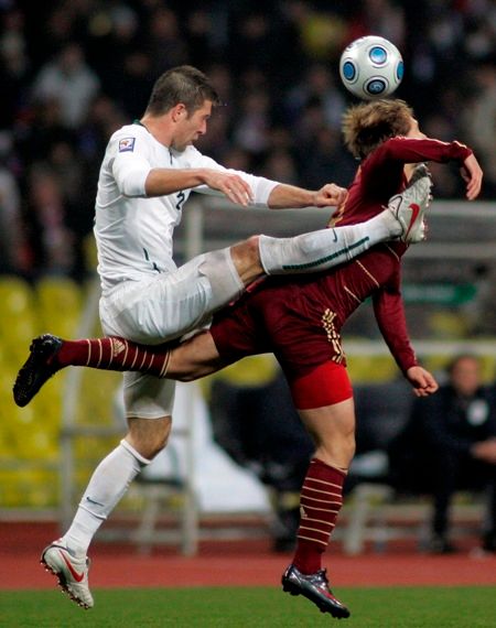 Roman Pavljučenko a Mišo Brečko bojují o míč v barážovém utkání o postup na MS Rusko - Slovinsko. | Foto: Reuters